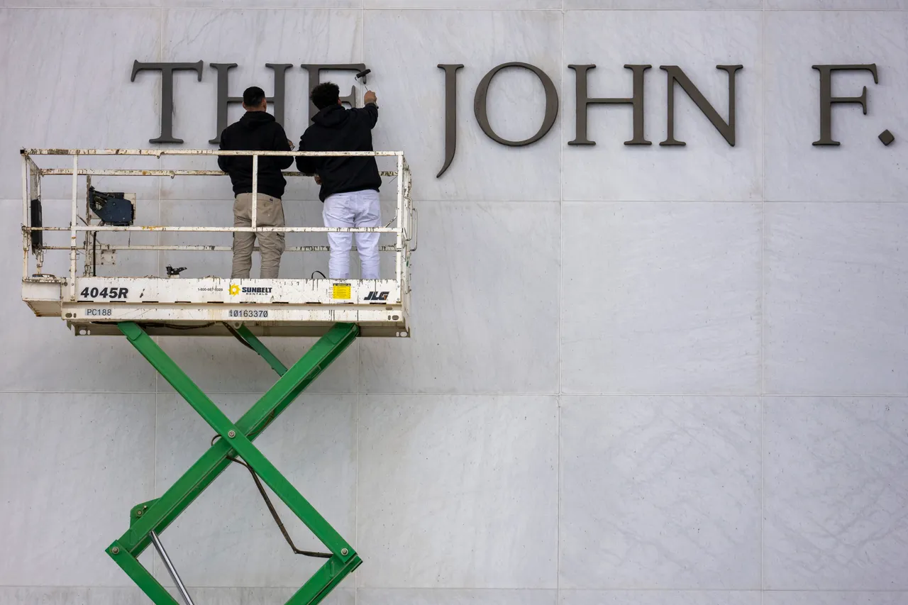 Workers repaint lettering outside the The John F. Kennedy Memorial Center for the Performing Arts after the building was renamed in honor of US President Donald Trump on December 19, 2025, in Washington, DC. The US capital's renowned John F. Kennedy arts center was renamed the "Trump-Kennedy Center" after President Donald Trump, the White House announced on December 18, 2025. Press Secretary Karoline Leavitt said the center's board -- which Trump purged of Democrats earlier this year -- voted for the change because of the Republican's "unbelievable work" in overhauling the famed venue. (Photo by Jim WATSON / AFP via Getty Images)