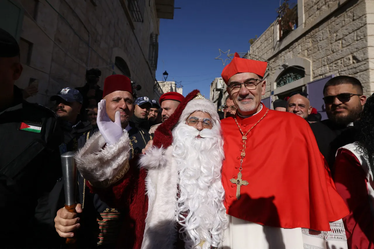 Latin Patriarch of Jerusalem Italian Pierbattista Pizzaballa poses for a photograph with a man dressed up as Santa Claus as he is welcomed by pilgrims, tourists and Palestinians upon arrival to lead the Christmas Mass in the Church of the Nativity in the Israeli-occupied West Bank city of Bethlehem, believed to be the birthplace of Jesus Christ, on December 24, 2025. Palestinian Scouts marched under a clear blue sky in Bethlehem on December 24, 2025, as the Palestinian city emerged from the shadow of the war in Gaza to celebrate its first festive Christmas in more than two years. Throughout the Gaza war that began with Hamas's attack on Israel in October 2023, a sombre tone marked Chistmases in Bethlehem, the biblical birthplace of Jesus Christ. (Photo by HAZEM BADER / AFP via Getty Images)