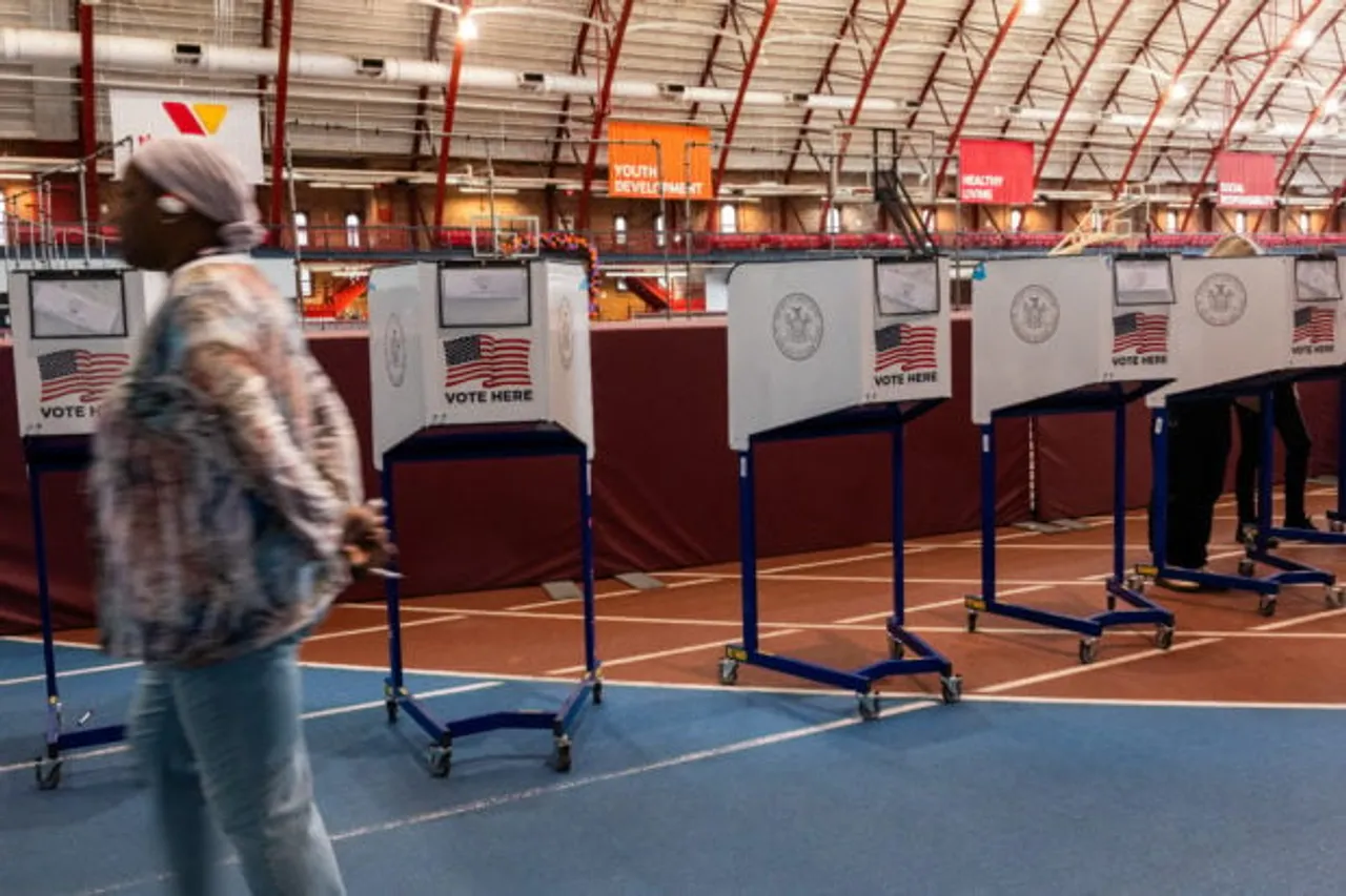 A poll worker walks by voting booths as New Yorkers participate in early voting at a polling site in Brooklyn on October 29, 2024 in New York City. As Election Day approaches on November 5th, millions of Americans are casting their ballots early at polling sites or drop boxes. (Photo by Spencer Platt/Getty Images)