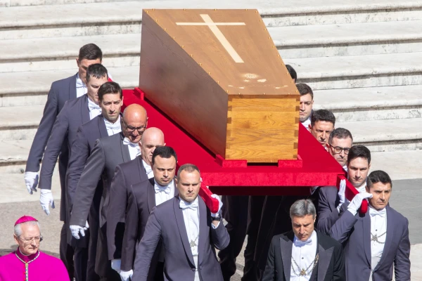 Pallbearers carry the wooden coffin of Pope Francis, marked with a cross, into St. Peter's Square for the funeral Mass on April 26, 2025. Credit: Daniel Ibáñez/CNA