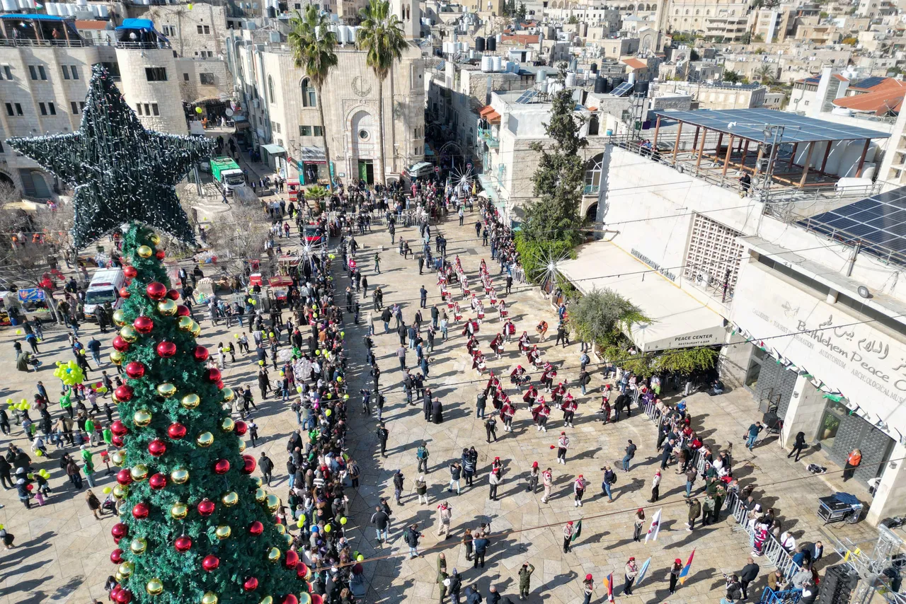 An aerial view shows scouts marching during Christmas eve celebrations on Manger Square outside the Church of the Nativity (unseen) in Bethlehem, in the Israeli-occupied West Bank, on December 24, 2025. (Photo by HAZEM BADER / AFP via Getty Images)