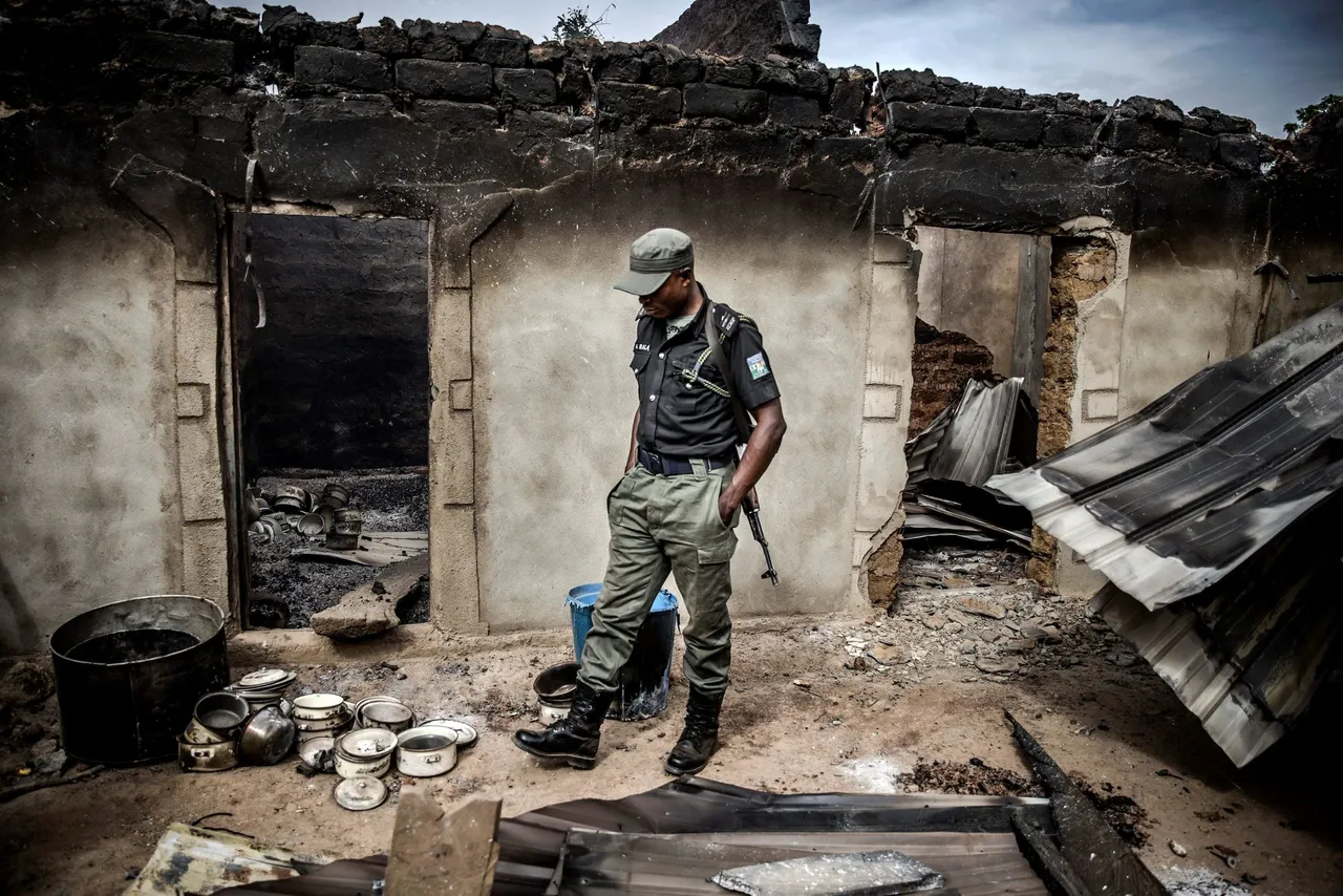 A Nigerian Police Officer patrols an area of destroyed and burned houses after a recent Fulani attack in the Adara farmers' village of Angwan Aku, Kaduna State, Nigeria on April 14, 2019. (Photo credit should read LUIS TATO/AFP via Getty Images)
