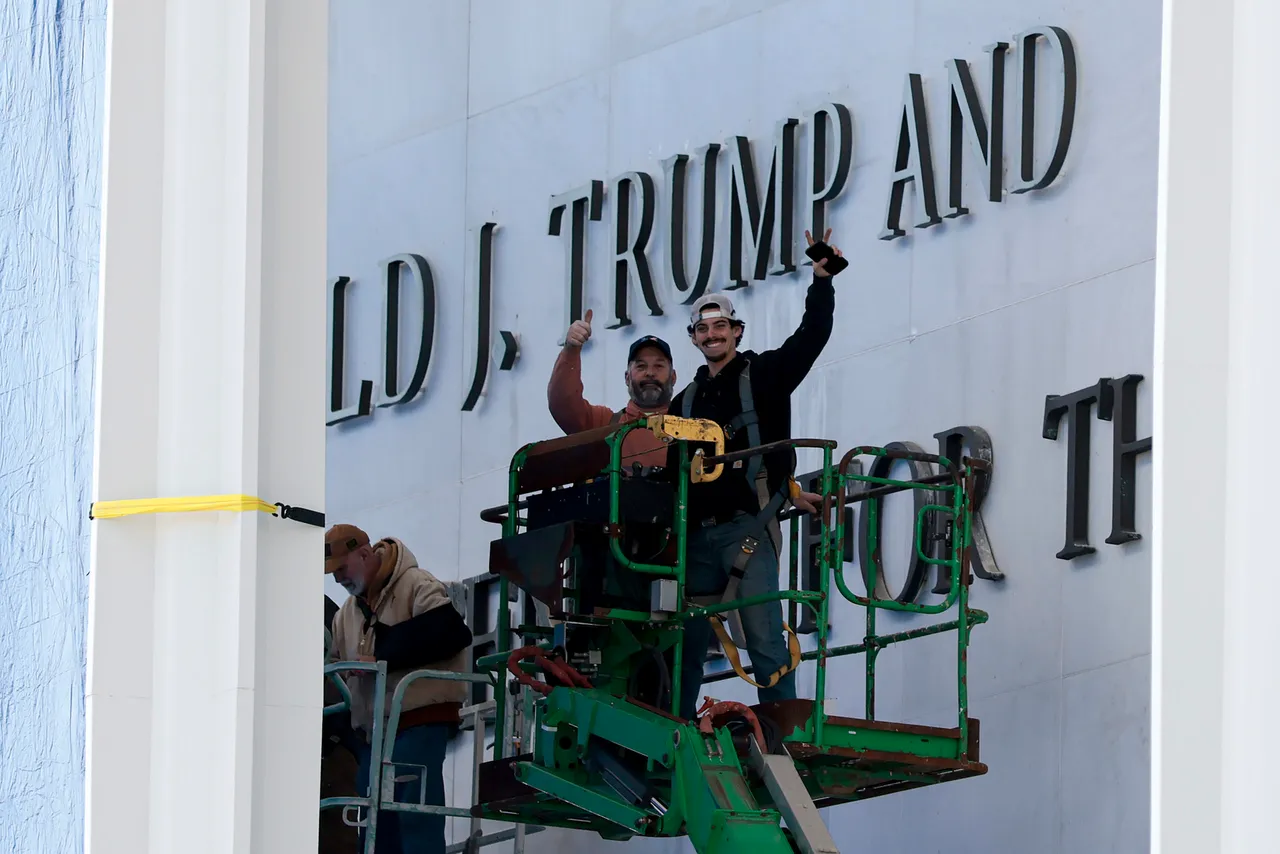 WASHINGTON, DC - DECEMBER 19: Workers pose for a photo after adjusting the name of the “John F. Kennedy Memorial Center for the Performing Arts