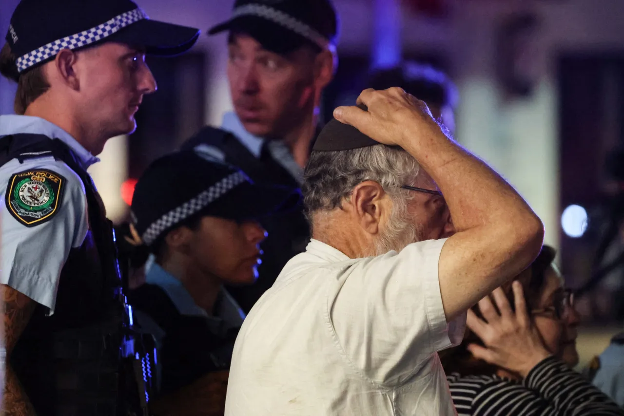 A member of the Jewish community reacts as he walks with police towards the scene of a shooting at Bondi Beach in Sydney on December 14, 2025. (Photo by DAVID GRAY / AFP via Getty Images)