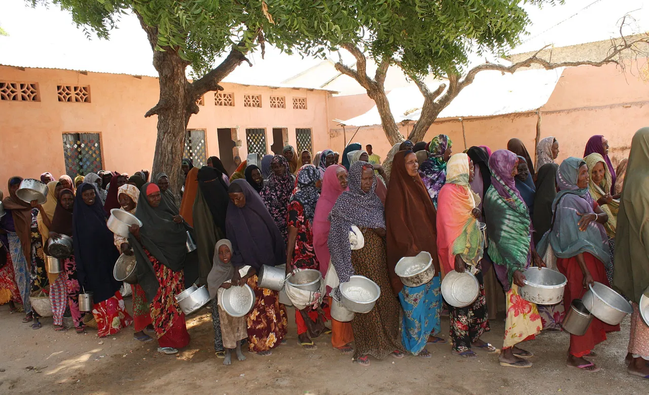 Somalis displaced people wait to receive food rations at a distribution centre of World Food program (WFP) in the Dharkenley District of Mogadishu on December 13, 2010, the camp feeds several hundred families a day amid an increasing number of people depending on food aid in Somalia. (Photo by ABDURASHID ABIKAR/AFP via Getty Images)