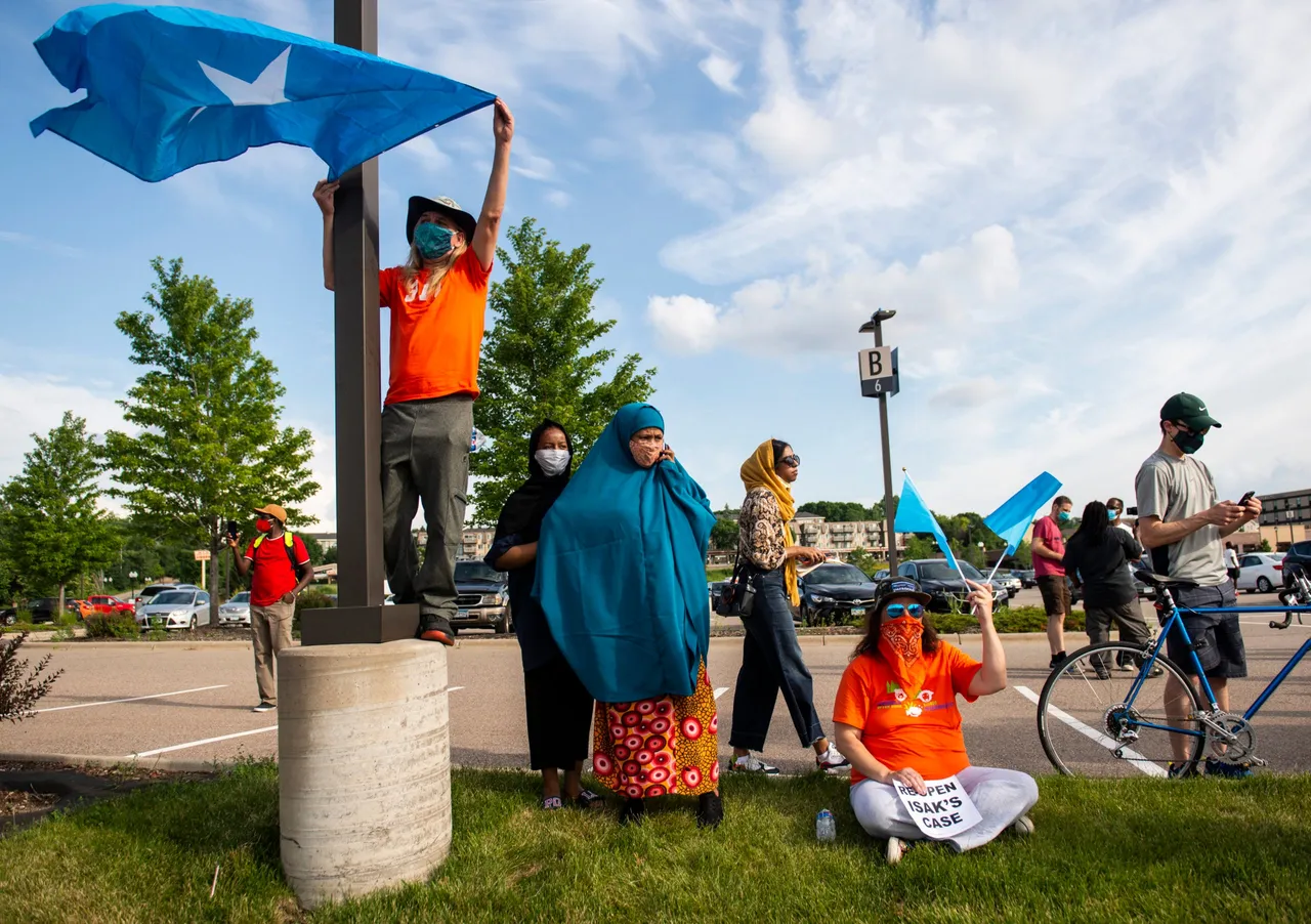 EAGAN, MN - JULY 01: People hold up Somali flags during a protest calling for justice for Isak Aden on July 1, 2020 in Eagan, Minnesota. (Photo by Stephen Maturen/Getty Images)