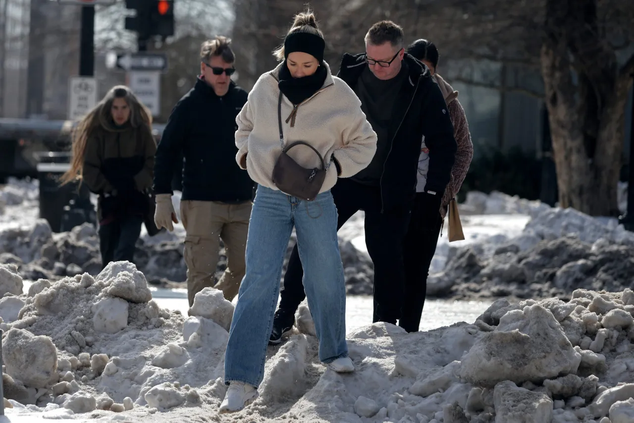 WASHINGTON, DC - JANUARY 29: Pedestrians walk over a snow-covered sidewalk on Massachusetts Avenue on January 29, 2026 in Washington, DC. (Photo by Alex Wong/Getty Images)