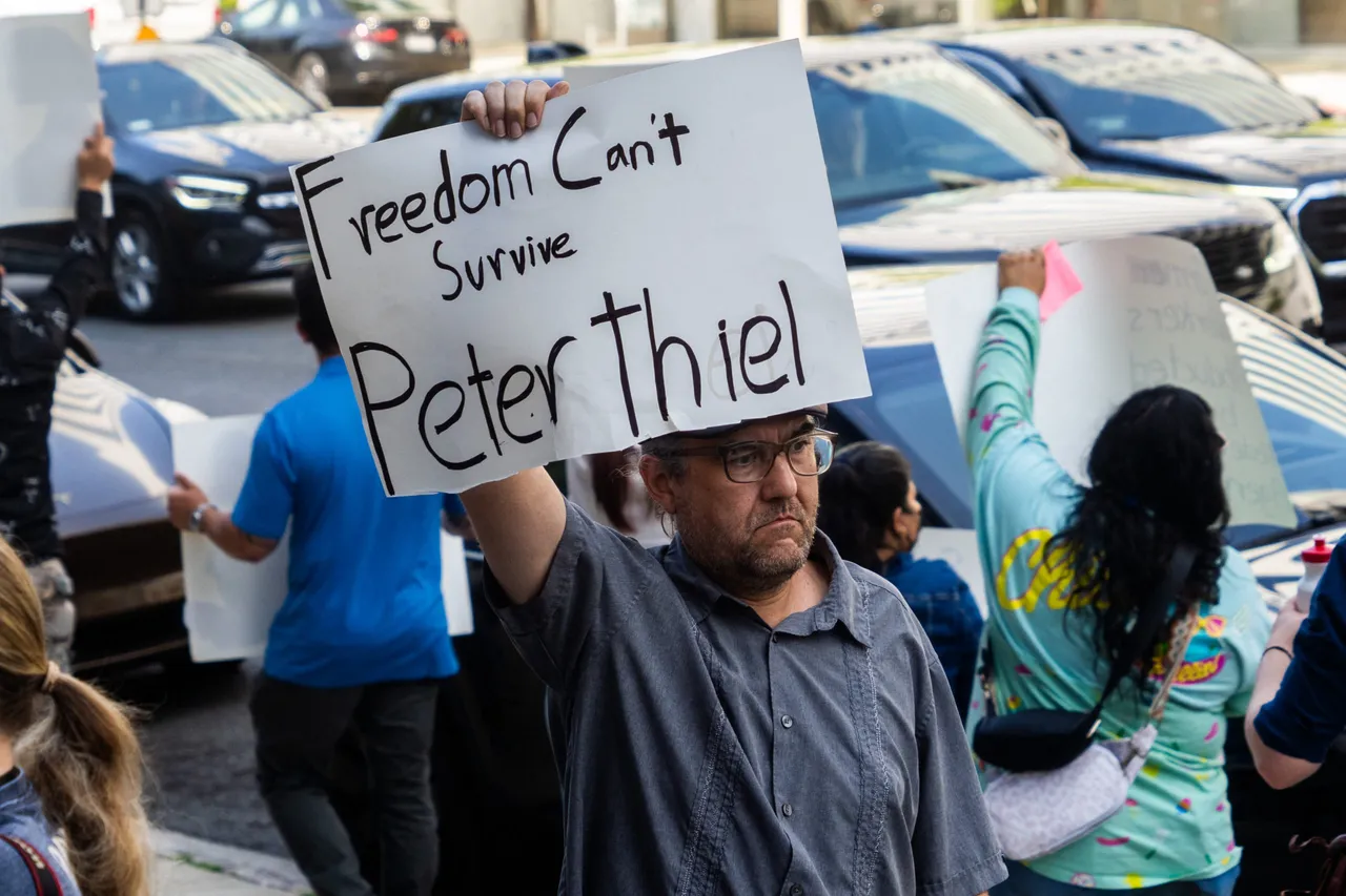 A protestor holds a sign reading Freedom Can't Survive Peter Thiel during a demonstration targeting tech billionaires on June 13 2025 in Los Angeles California USA. (Photo by MADISON SWART/Hans Lucas/AFP via Getty Images)