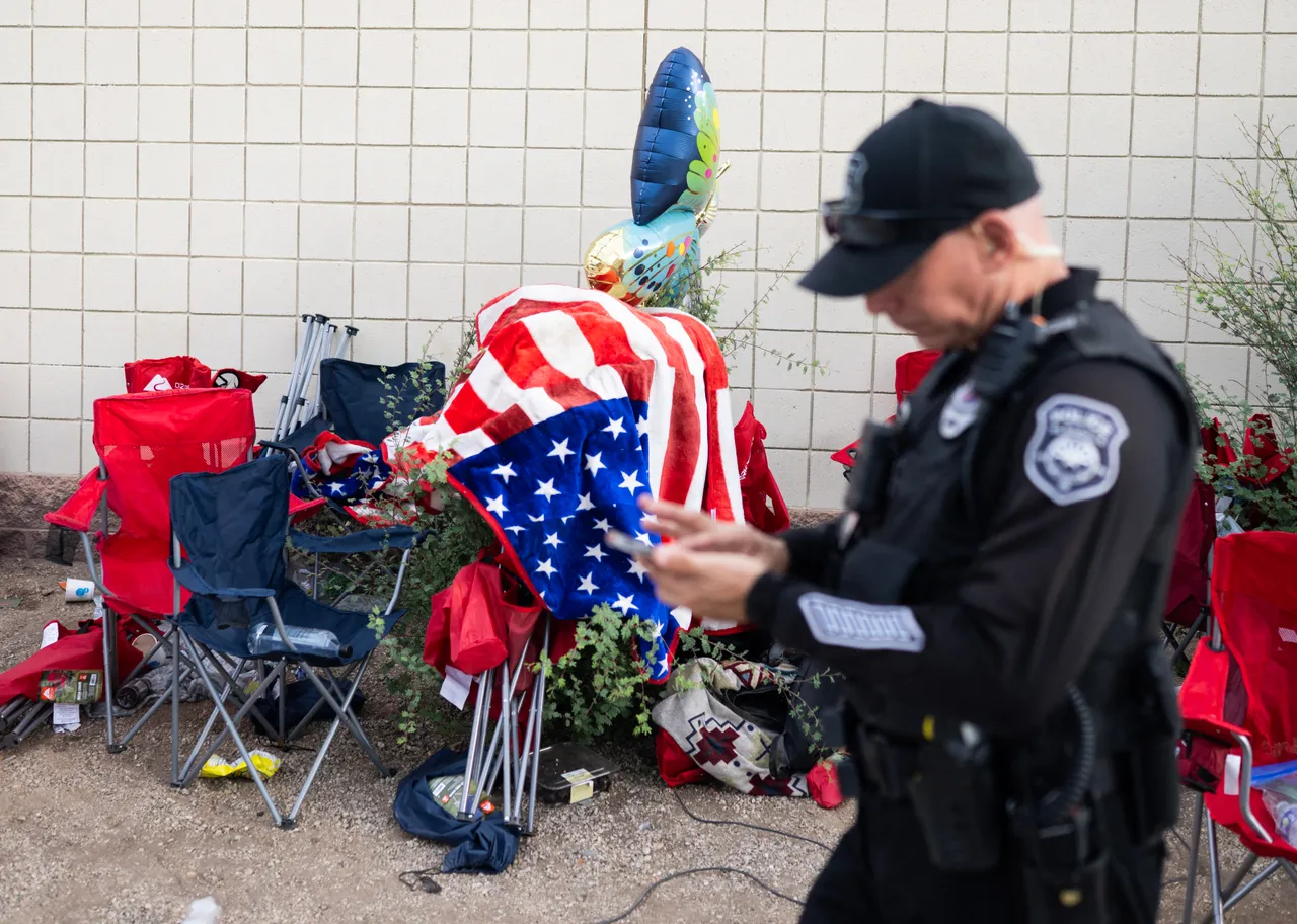 A police officer passes discarded chairs and trash outside the memorial for Charlie Kirk. (Photo by ANDREW CABALLERO-REYNOLDS/AFP via Getty Images)