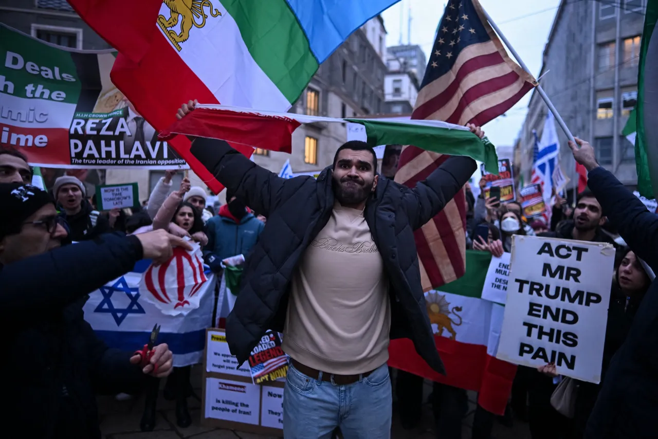 An anti-Iranian regime protester tears the national flag of the Islamic Republic of Iran apart during a gathering outside the US Consulate in Milan, on January 13, 2026. (Photo by Piero Piero Cruciatti / AFP via Getty Images)