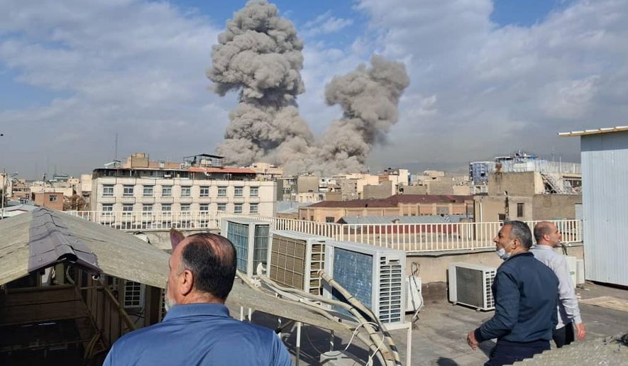 People watch as smoke rises on the skyline after an explosion in Tehran, Iran, Saturday, Feb. 28, 2026.(AP Photo)