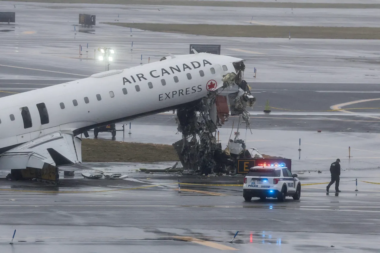 An Air Canada Express CRJ-900 sits on the runway after colliding with a Port Authority fire truck at LaGuardia Airport in New York, on March 23, 2026. A plane carrying dozens of people collided with a fire truck on a runway at New York's LaGuardia airport, killing the pilot and co-pilot and causing "serious injuries" to others, authorities said Monday. Due to the crash late Sunday, US aviation authorities halted all flights at LaGuardia, and the port authority said the airport would stay shut until at least 2:00 pm (1800 GMT) "to allow for a thorough investigation." (Photo by TIMOTHY A. CLARY / AFP via Getty Images)