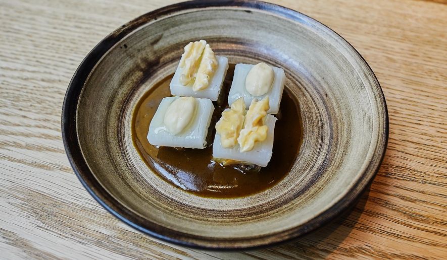 A cured squid, white cabbage, hazelnuts and walnuts dish served at restaurant Kadeau in Copenhagen, Denmark, Feb. 12, 2026. (AP Photo/James Brooks)