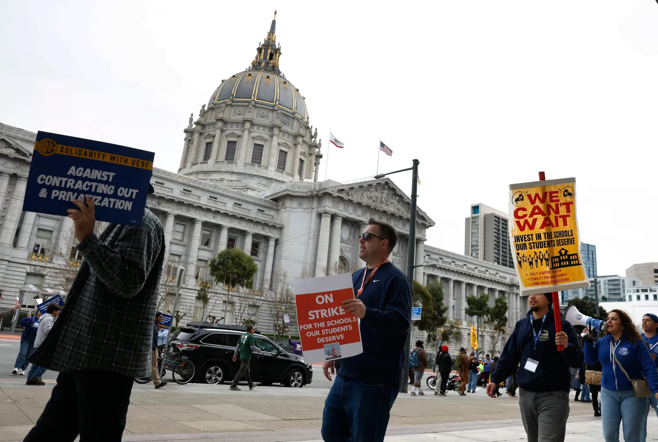 Teachers with the San Francisco Unified School District hold signs as they picket outside of San Francisco City Hall, Photo by Justin Sullivan, Getty Images