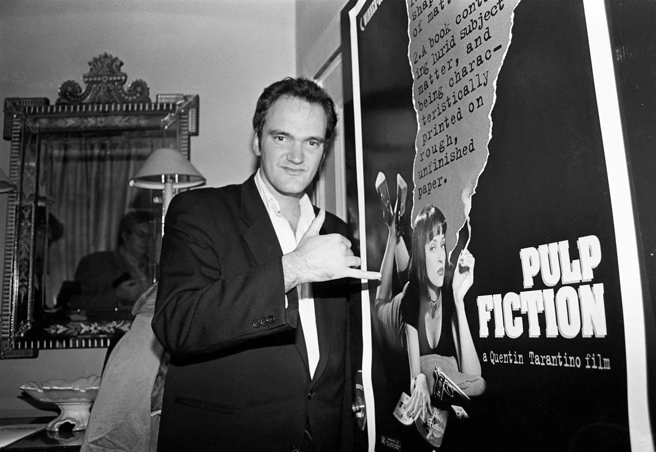 Director Quentin Tarantino standing by a poster for his film 'Pulp Fiction', London, United Kingdom, 1994. (Photo by Martyn Goodacre/Getty Images)