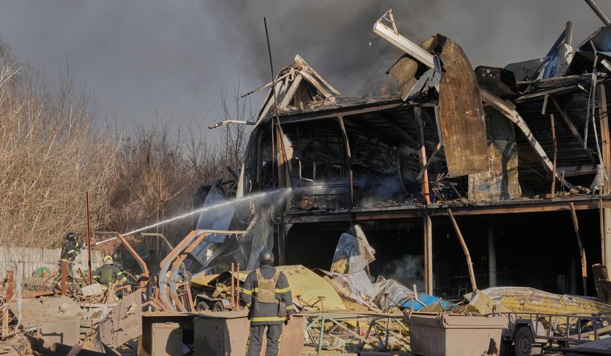Firefighters put out the fire at railway workshops following a Russia missile and drone attack, in Brovary, close to Kyiv, Ukraine, Saturday, March 14, 2026. (AP Photo/Efrem Lukatsky)