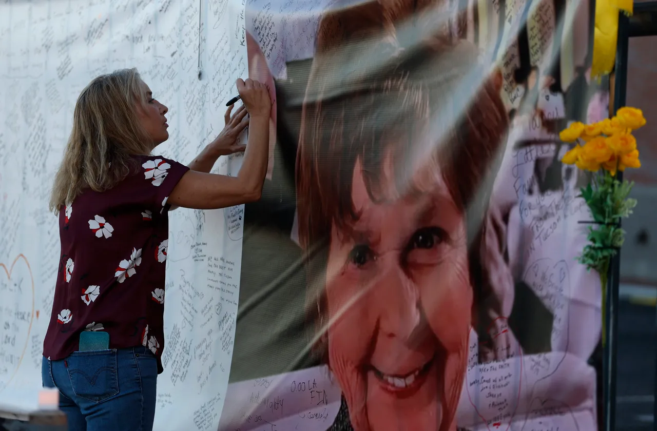 TUCSON, ARIZONA - MARCH 01: A visitor writes a message on a banner as she visits a makeshift memorial for Nancy Guthrie in front of the KVOA television station on March 01, 2026 in Tucson, Arizona. Law enforcement officials continue to search for Nancy Guthrie, the 84-year-old mother of U.S. journalist and television host Savannah Guthrie, after she went missing from her home on the morning of February 1st. (Photo by Justin Sullivan/Getty Images)