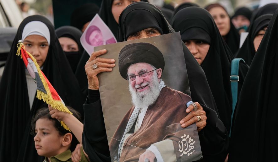 Iraqi women hold a portrait of Iran's late Supreme Leader Ayatollah Ali Khamenei and his son Ayatollah Mojtaba Khamenei, during a protest against U.S. and Israeli attacks on multiple cities across Iran, in the Shi'ite district of Kazimiyah in Baghdad, Iraq, Friday, April 3, 2026. (AP Photo/Hadi Mizban)