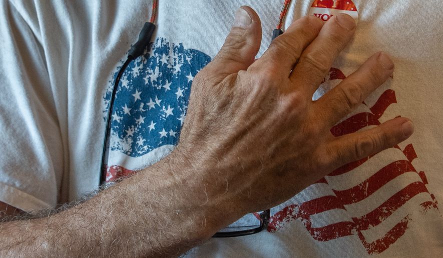 Goochland Democratic Committee member Richard Grebe stick an "I Voted" sticker on his shirt during a lunch meeting on future get-out-the-vote efforts for the Virginia redistricting referendum, Thursday, April 2, 2026, at GG's Pizza in Maiden, Va. (AP Photo/Julia Demaree Nikhinson)