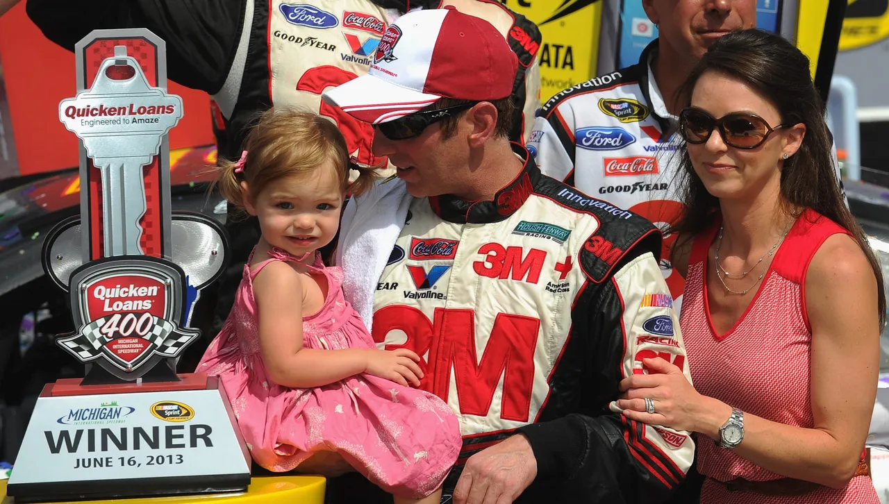 BROOKLYN, MI - JUNE 16: Greg Biffle, driver of the #16 3M/Give Kids a Smile Ford, celebrates in Victory Lane wife his wife Nicole and daughter Emma after winning the NASCAR Sprint Cup Series Quicken Loans 400 at Michigan International Speedway on June 16, 2013 in Brooklyn, Michigan. (Photo by Will Schneekloth/Getty Images)