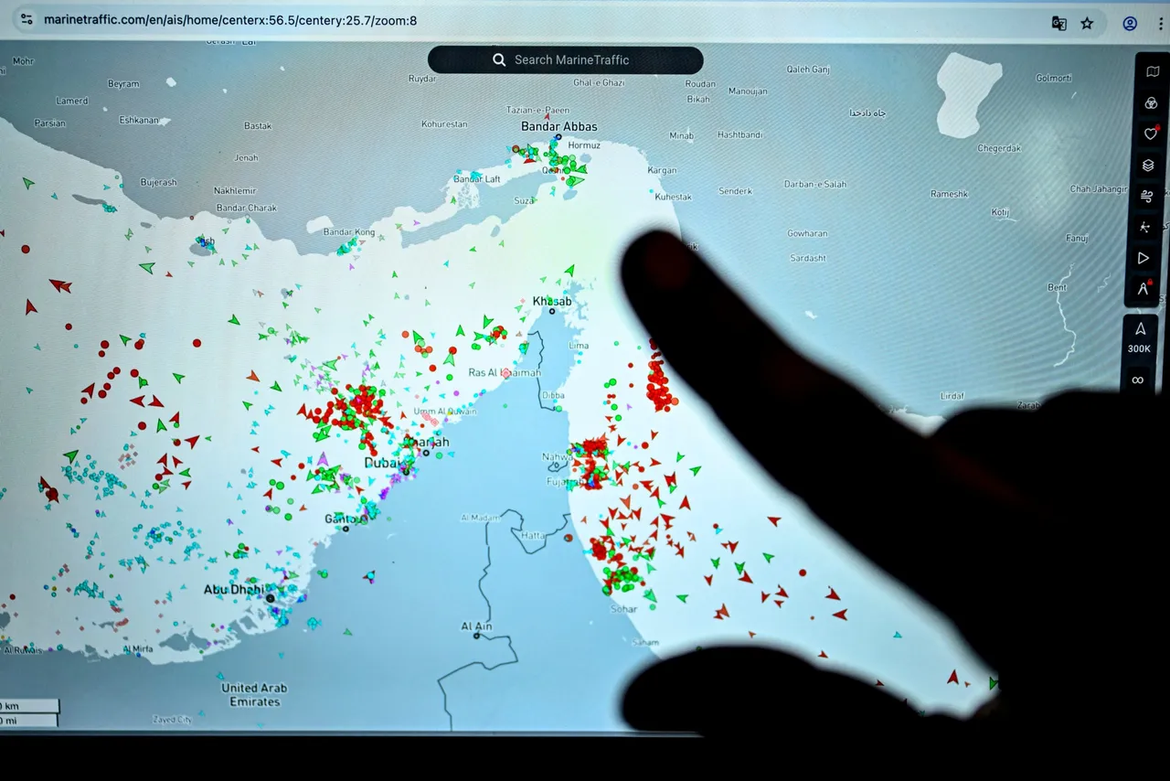 A person points at a page on the Marinetraffic website that shows commercial boats traffic on the edge of the Strait of Hormuz near the Iranian coast, in Paris on March 4, 2026. (Photo by JULIEN DE ROSA / AFP via Getty Images)
