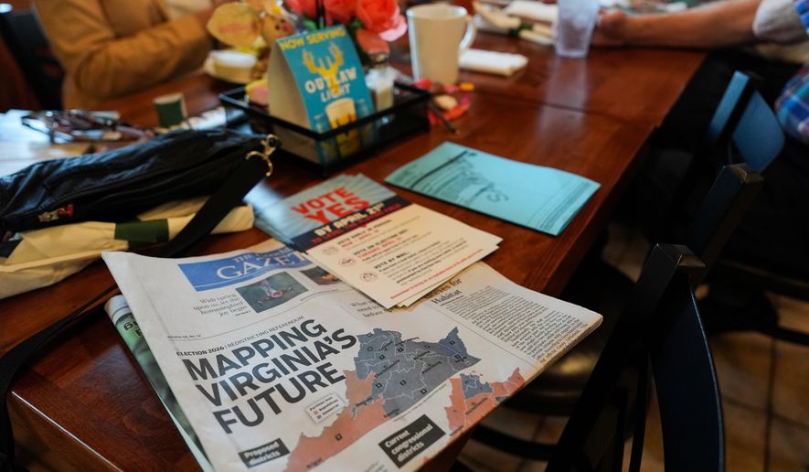 A print edition of the Goochland Gazette, with a front page story on the Virginia redistricting referendum, lies on a table at GG's Pizza as members of the Goochland Democratic Committee Jen Strozier, Doug Mock, Chris Svoboda, Richard Grebe and Judi Sheppard hold a lunch meeting on future get-out-the-vote efforts, Thursday, April 2, 2026, in Maiden, Va. (AP Photo/Julia Demaree Nikhinson)